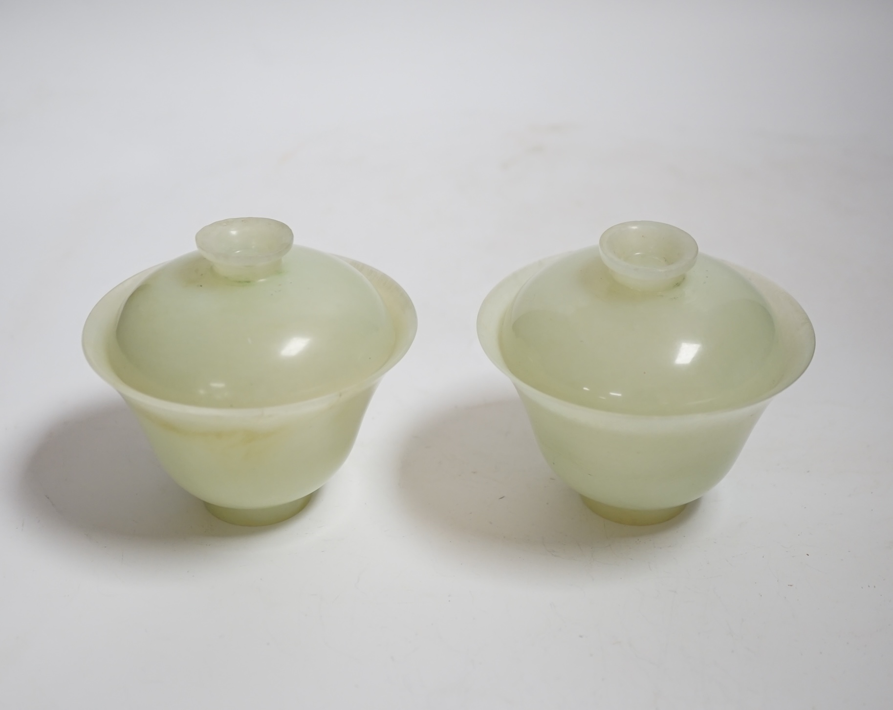 A pair of Chinese bowenite cups and covers, 10cm in diameter
